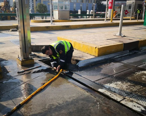 圖為工作人員對地磅進(jìn)行清淤處理